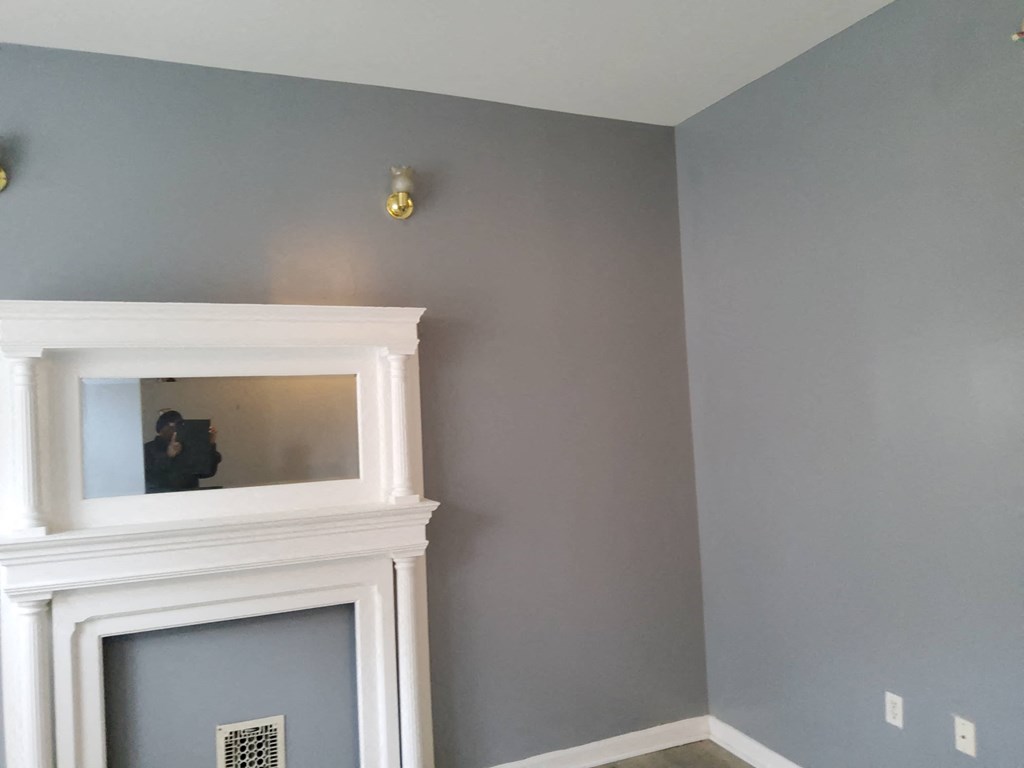 a room with a fireplace and a mirror on the wall