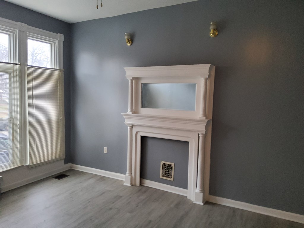 the living room has a fireplace and grey walls