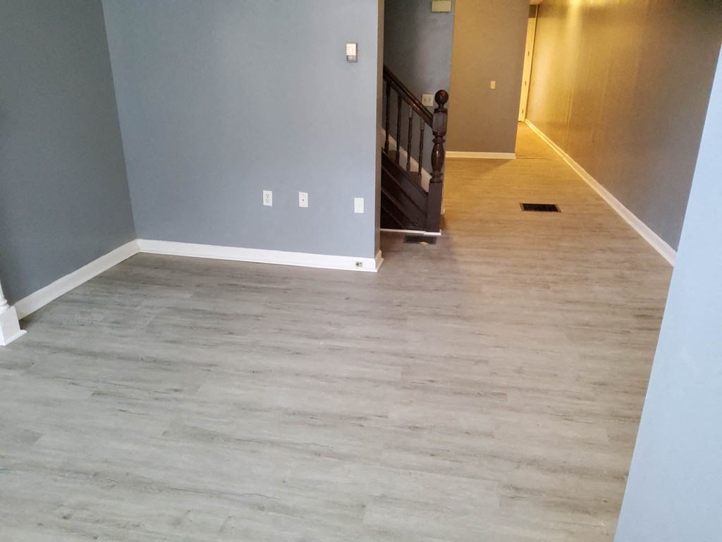 a living room with wood flooring and a staircase