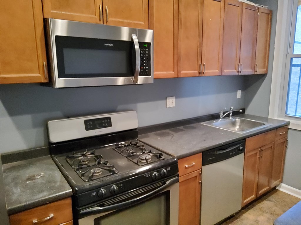 a kitchen with stainless steel appliances and wooden cabinets