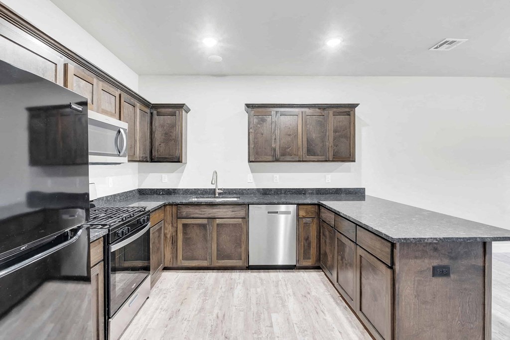 a kitchen with wooden cabinets and stainless steel appliances