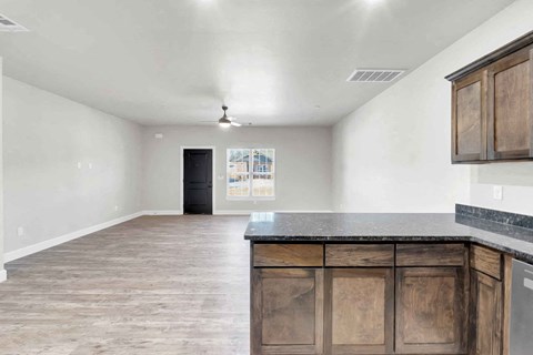 an empty kitchen with wooden cabinets and a counter top