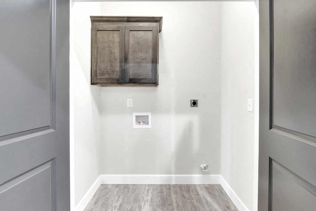 a small room with a wall cabinet and a door