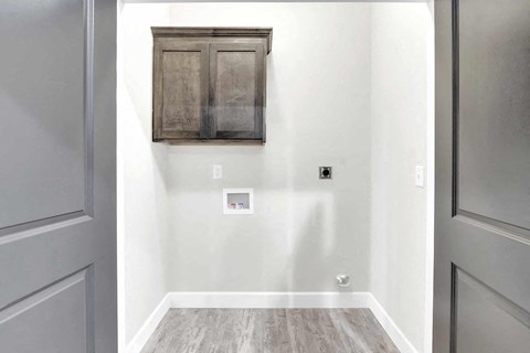 a small room with a wall cabinet and a door