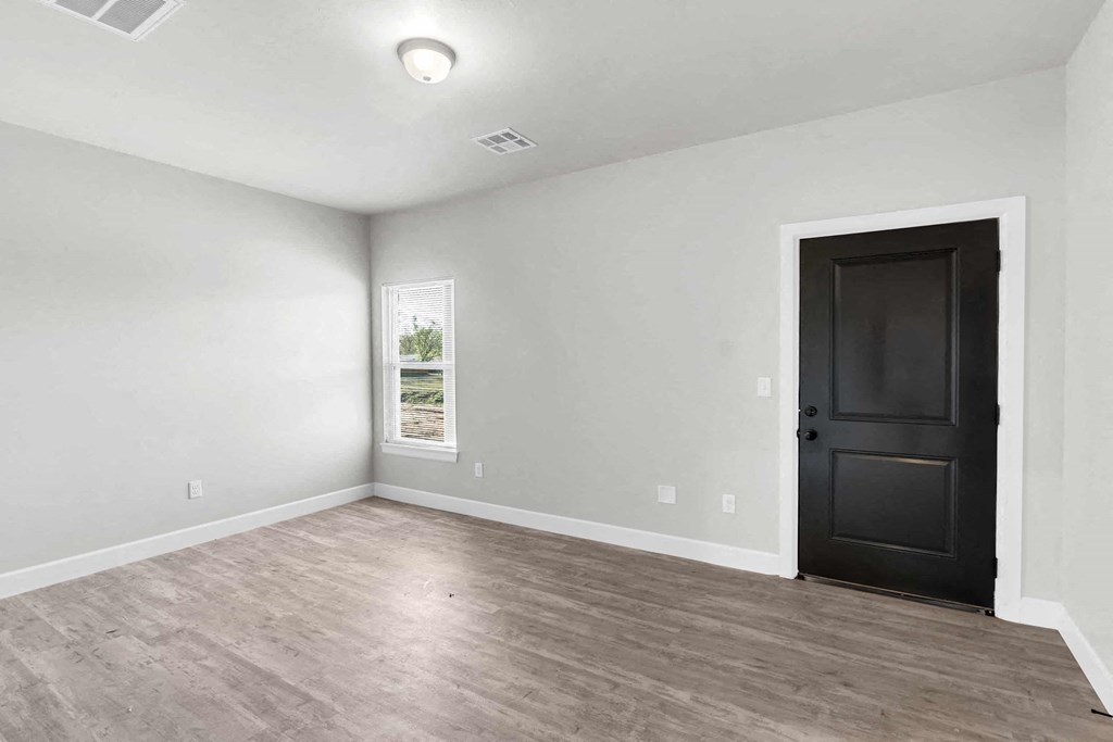an empty living room with white walls and a black door