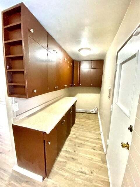 a empty kitchen with wooden cabinets and a white door