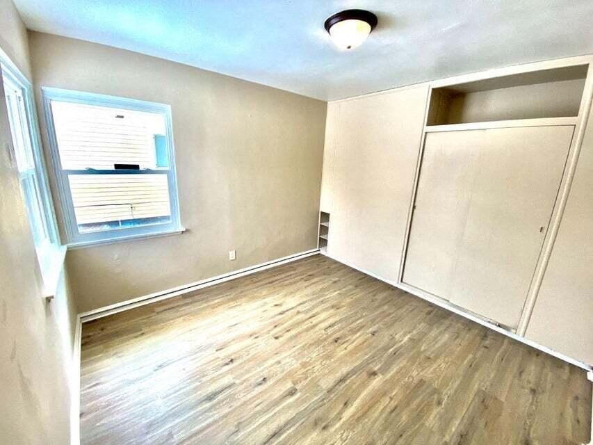 an empty room with wood floors and a window