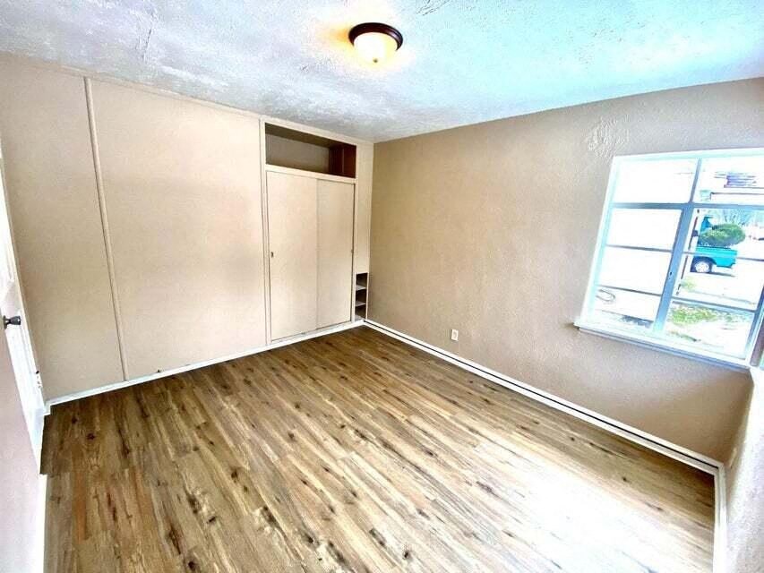 an empty room with wooden floors and a window