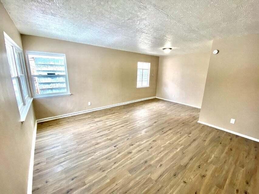 an empty living room with a hard wood floor