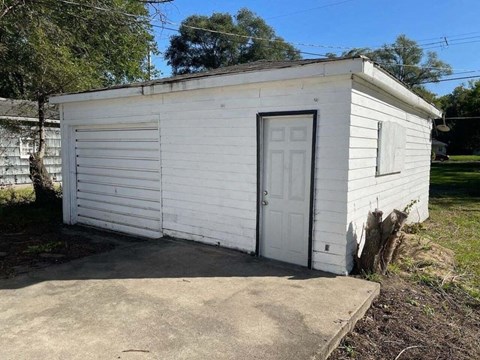a small white building with a white door
