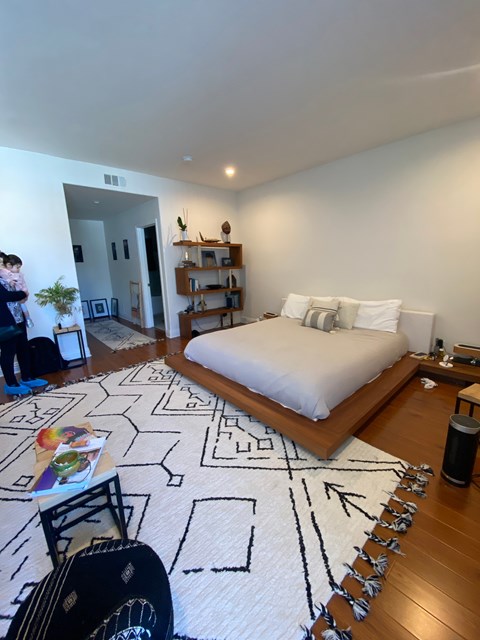 a bedroom with a bed and a rug in a house