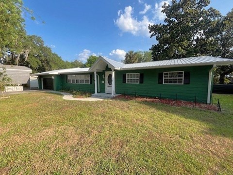 a green house with a yard in front of it