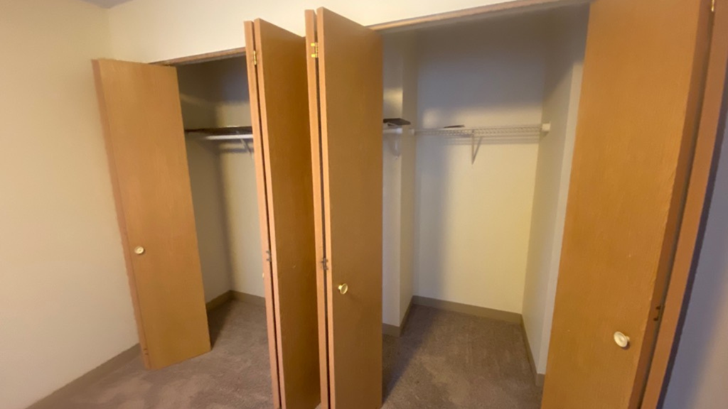 an empty closet in a room with three doors