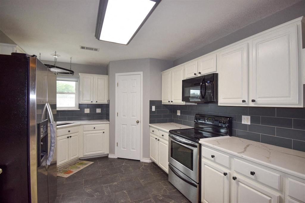 a kitchen with white cabinets and stainless steel appliances