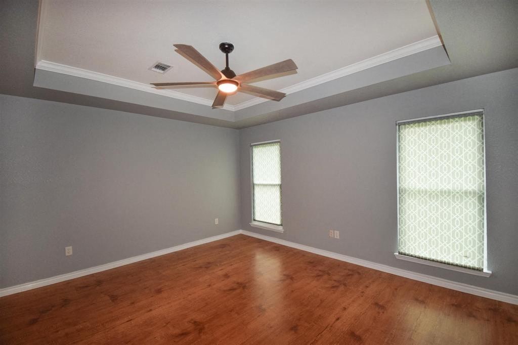 a living room with wood floors and a ceiling fan