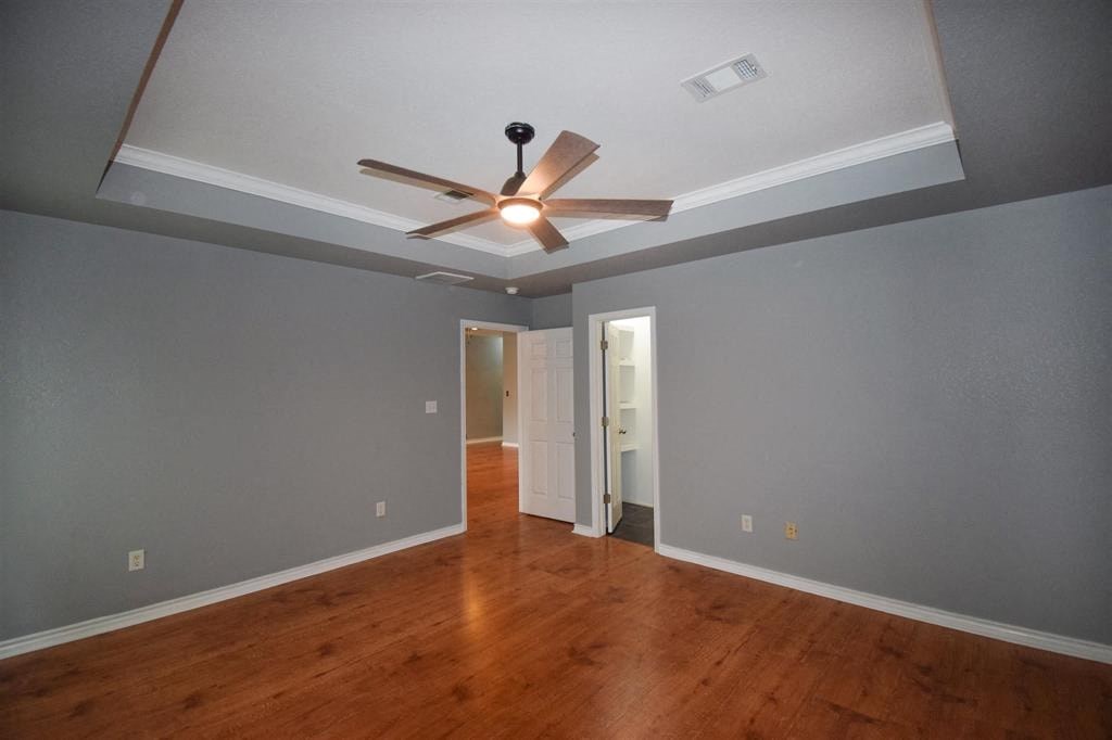 a living room with a ceiling fan and a wood floor