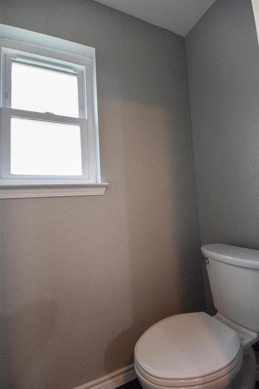 a small bathroom with a toilet and a window