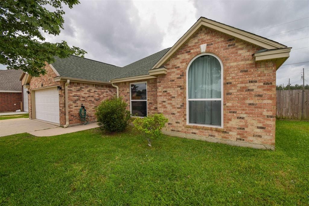 a brick house with a yard and a white garage