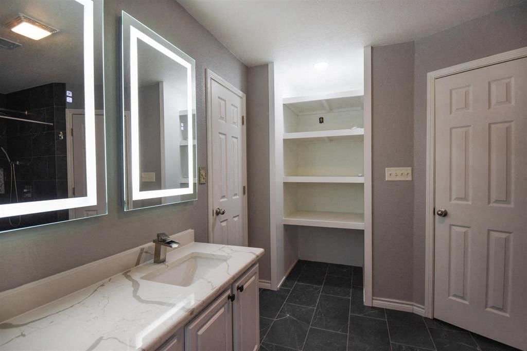 a bathroom with a sink and a mirror and a closet
