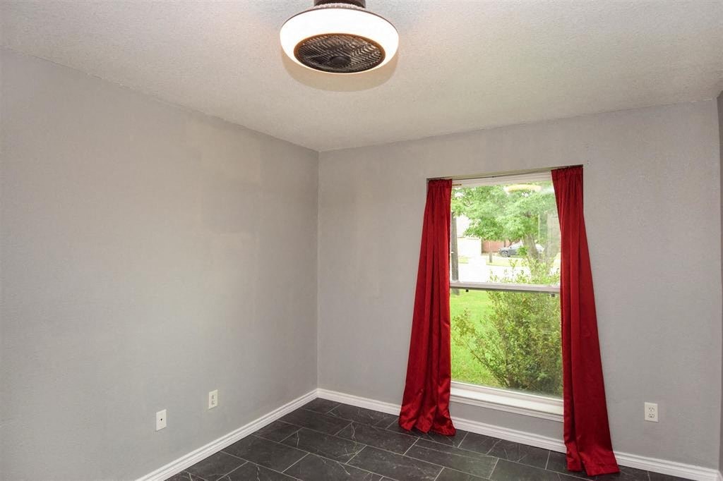 an empty room with red curtains and a window
