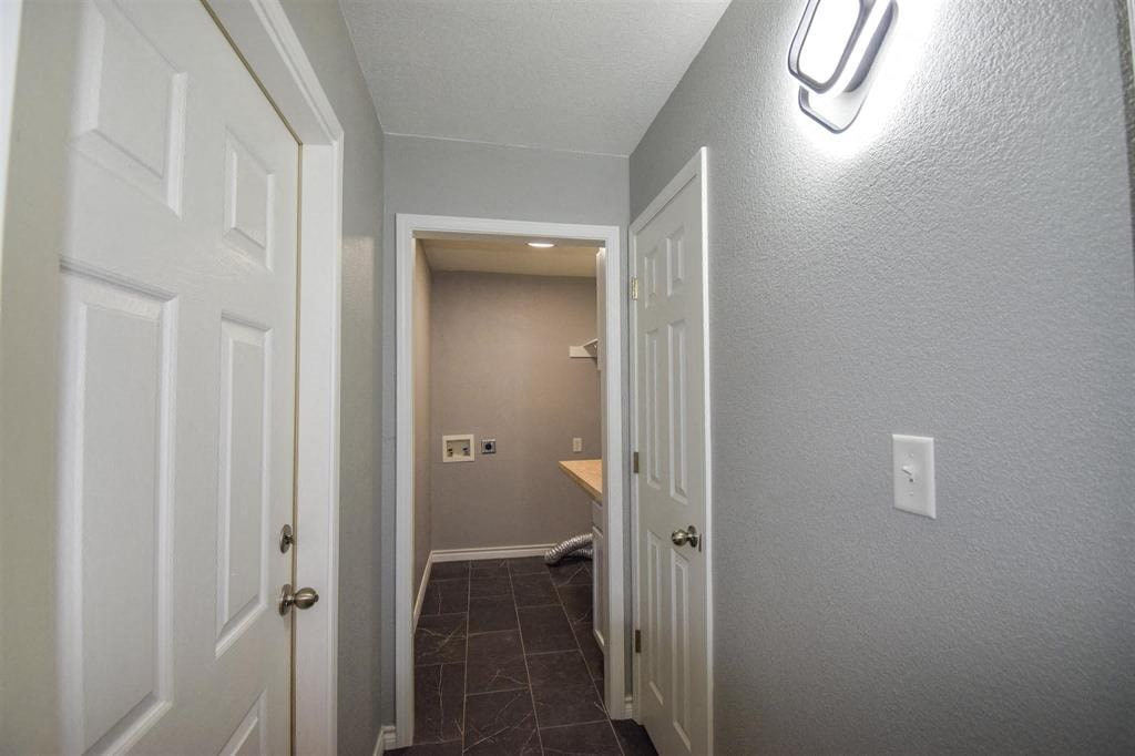 a hallway with a door to a bathroom and a sink