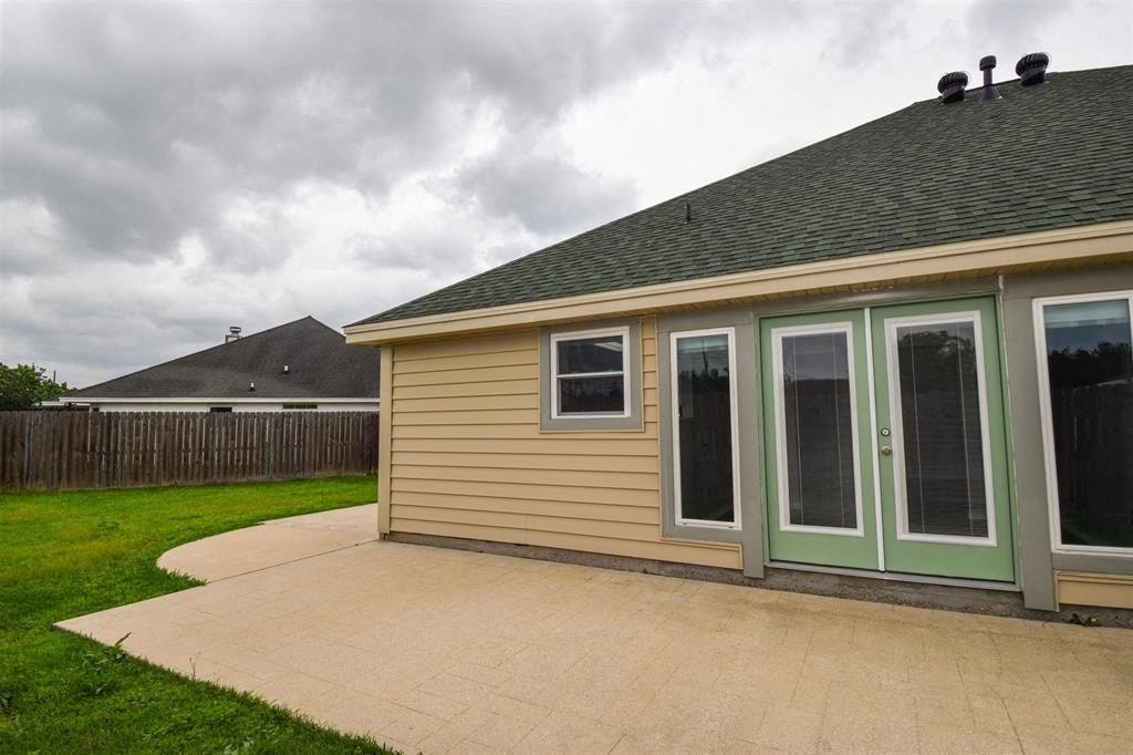 a side view of a house with a patio and a yard