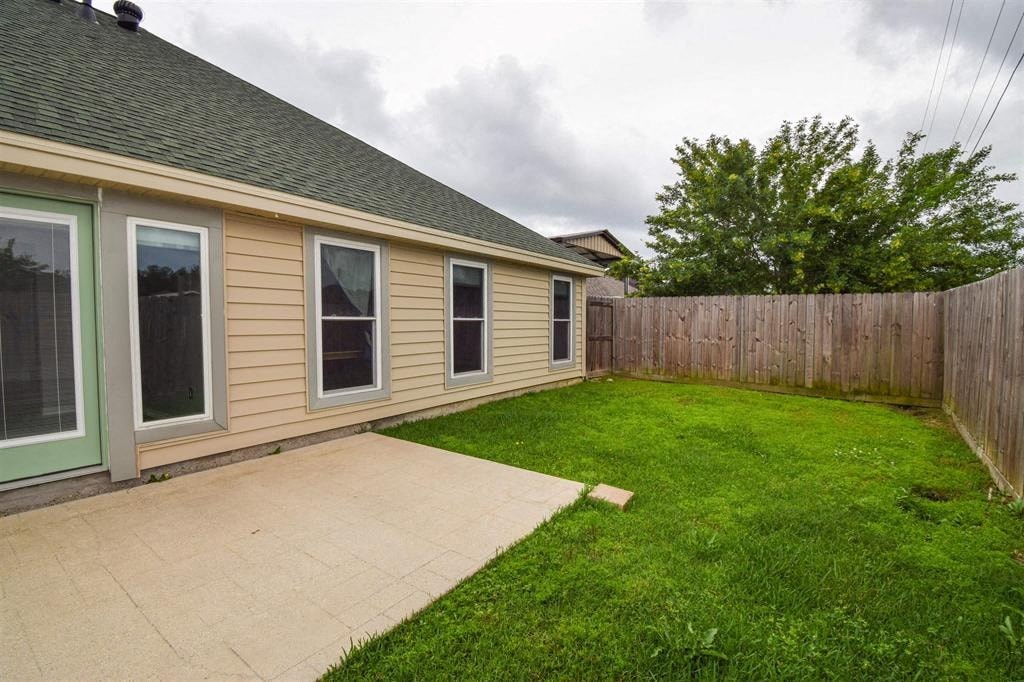 a side view of a house with a yard and a patio