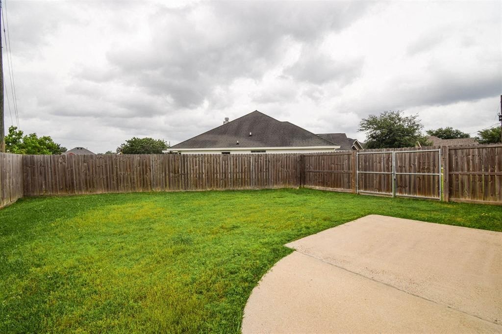 a backyard with a wooden fence and a house