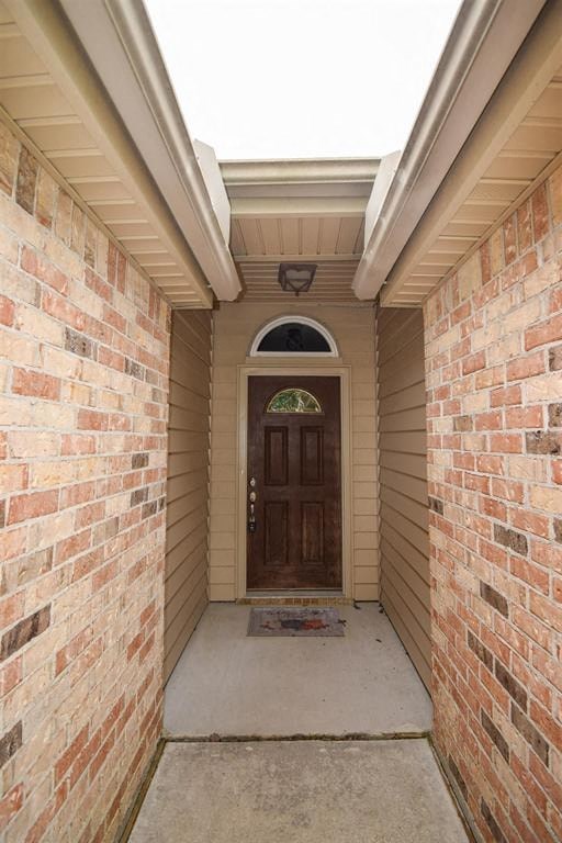 a walkway in front of a brick house with a wooden door