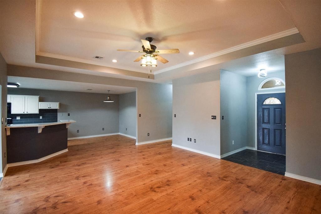 an empty living room with a ceiling fan