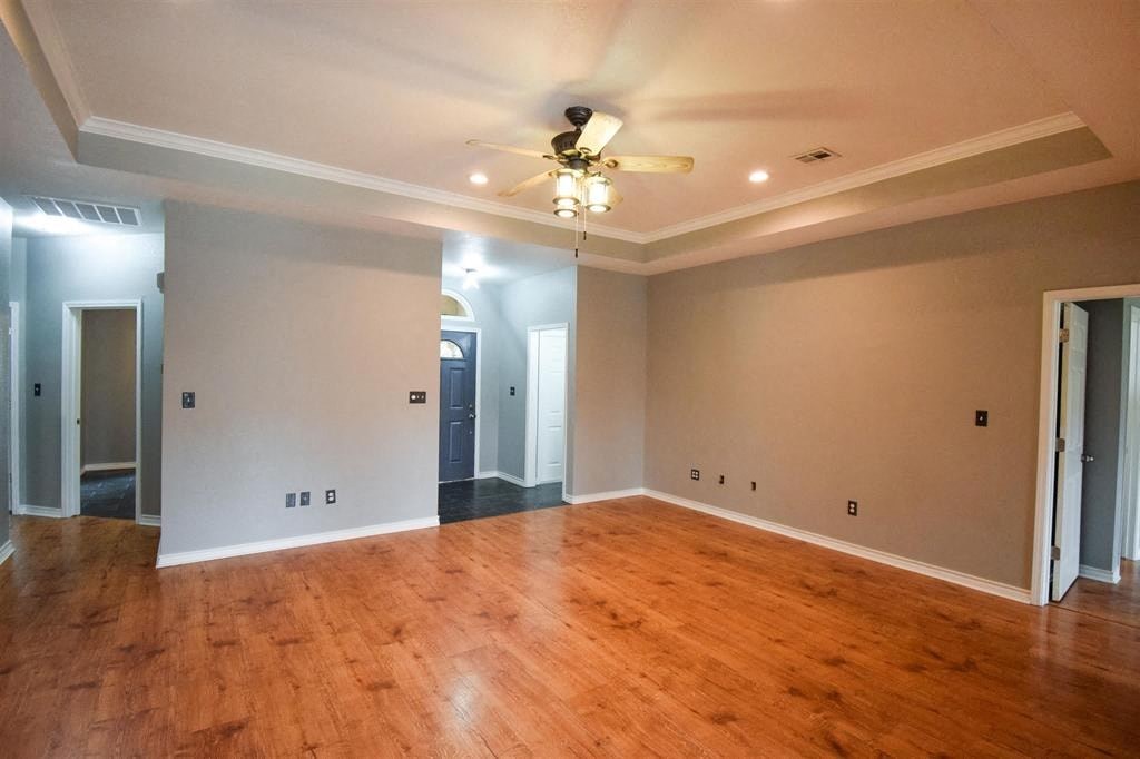 a living room with a ceiling fan and a wood floor