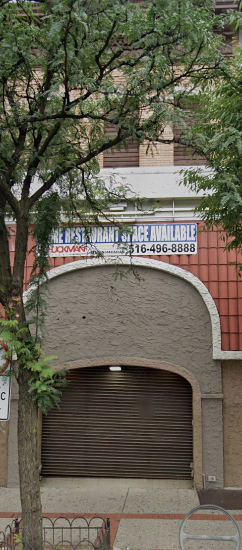 a building with a garage door and a tree