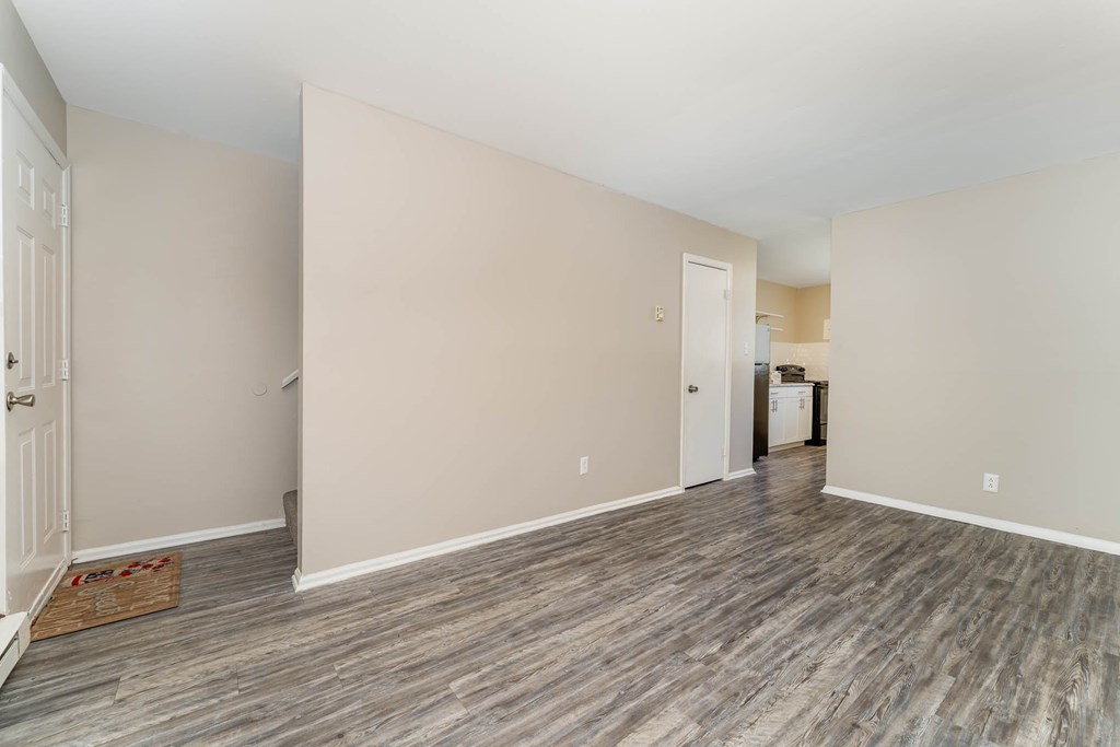 a renovated living room with wood flooring and white walls