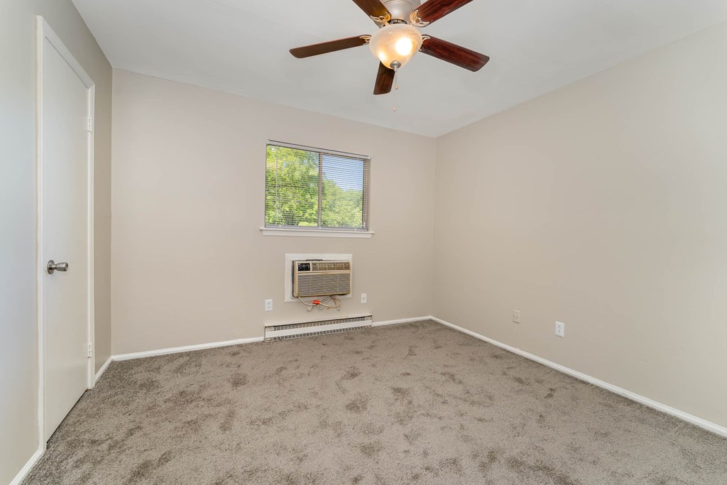 a room with carpet and a ceiling fan