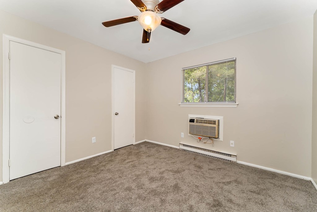 a living room with carpet and a ceiling fan