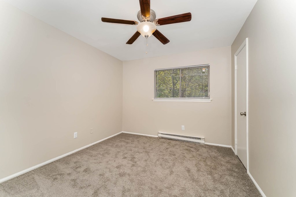 a room with carpet and a ceiling fan