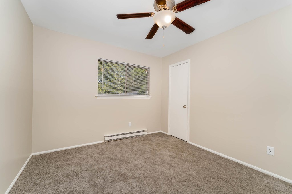a room with carpet and a ceiling fan
