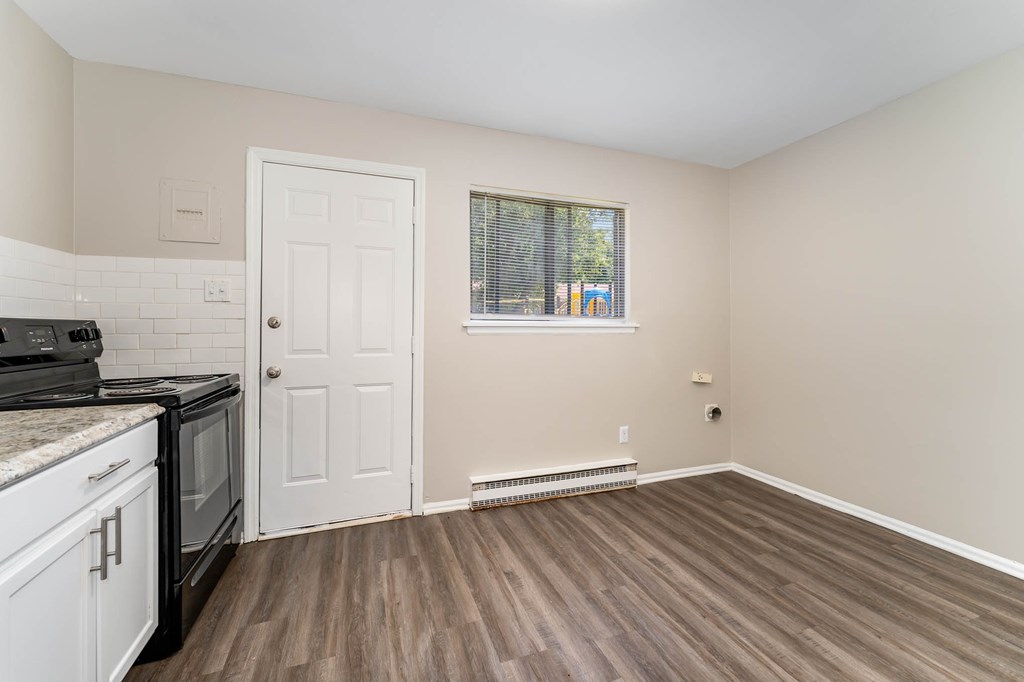 a kitchen with a stove and a white door