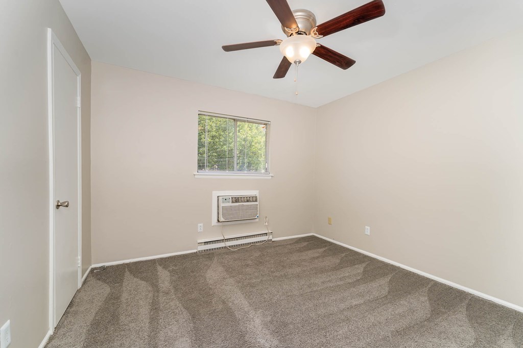 a room with carpet and a ceiling fan
