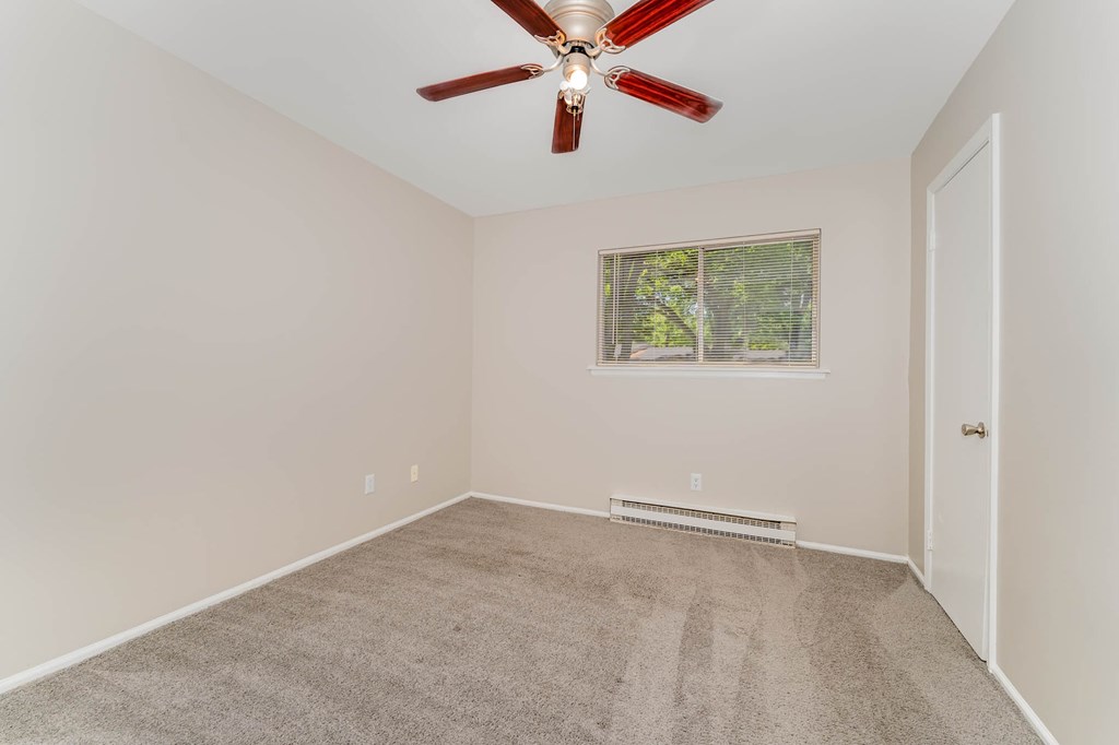 a room with carpet and a ceiling fan