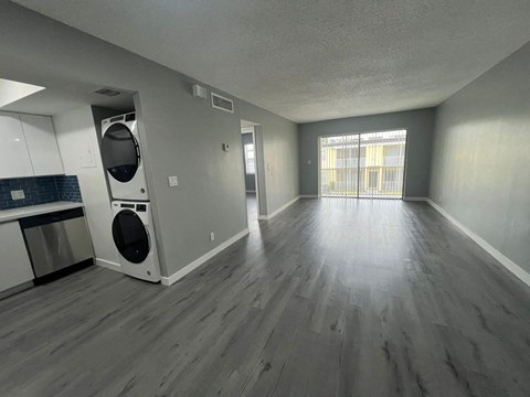 A spacious room with a washer and dryer built into the cabinetry.