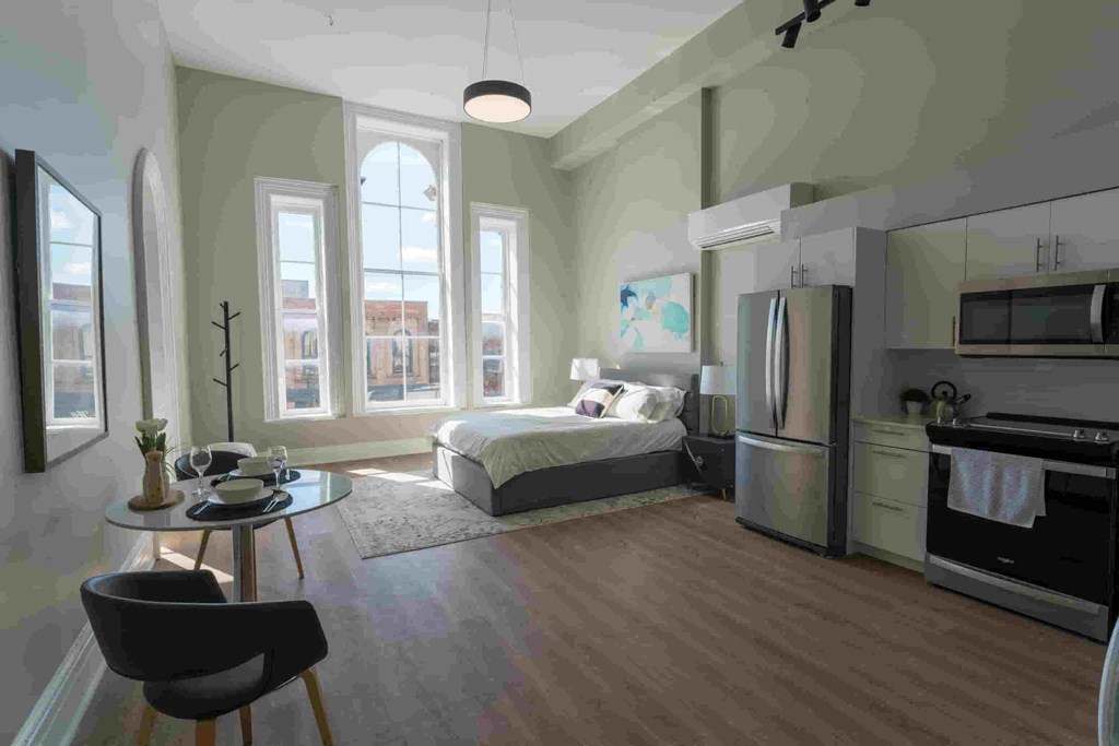 a rendering of a studio apartment with a bed and a refrigerator