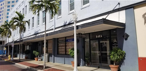 A white building with a black awning and a sign that reads "NONE" on it.