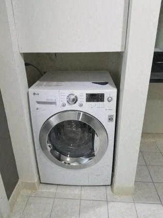 a washing machine in a bathroom with a door
