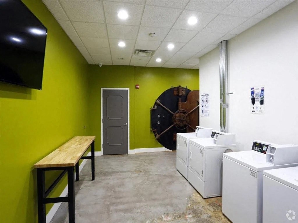 a laundry room with washing machines and a clock on the wall
