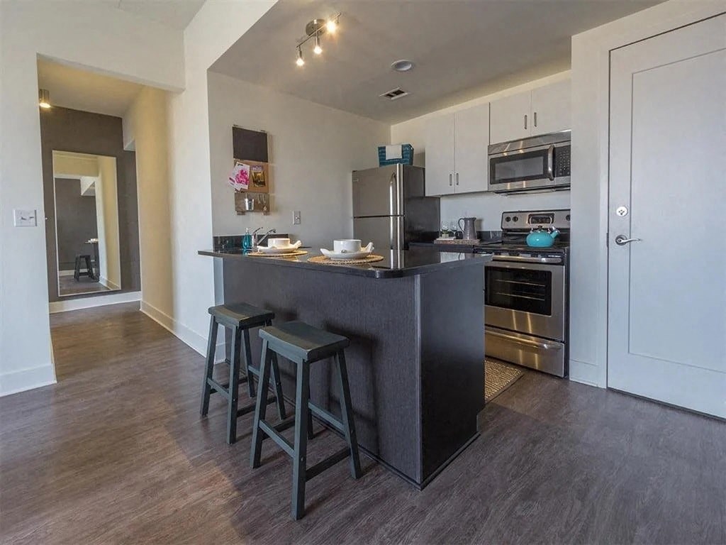 a kitchen with a large island with three stools