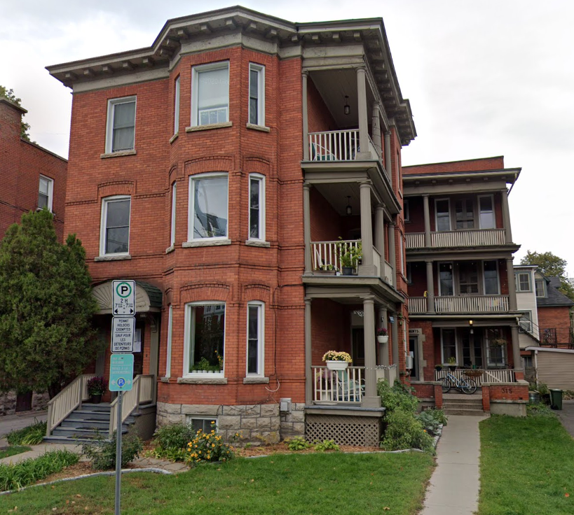 a red brick house with a sidewalk in front of it