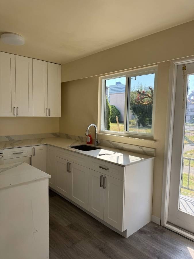A kitchen with white appliances and cabinets.