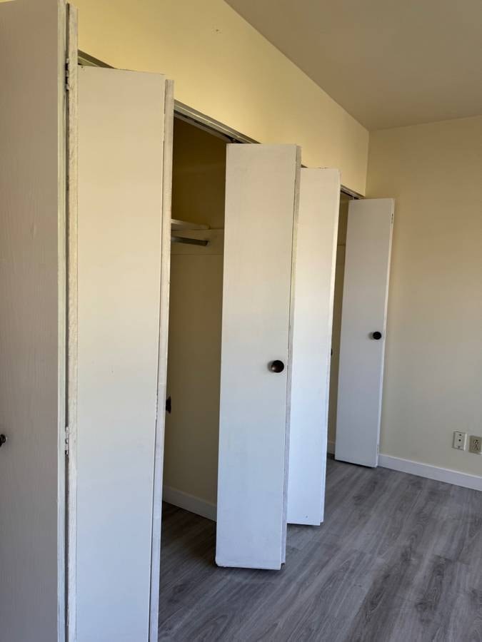 A white door is open to a hallway with a grey floor.