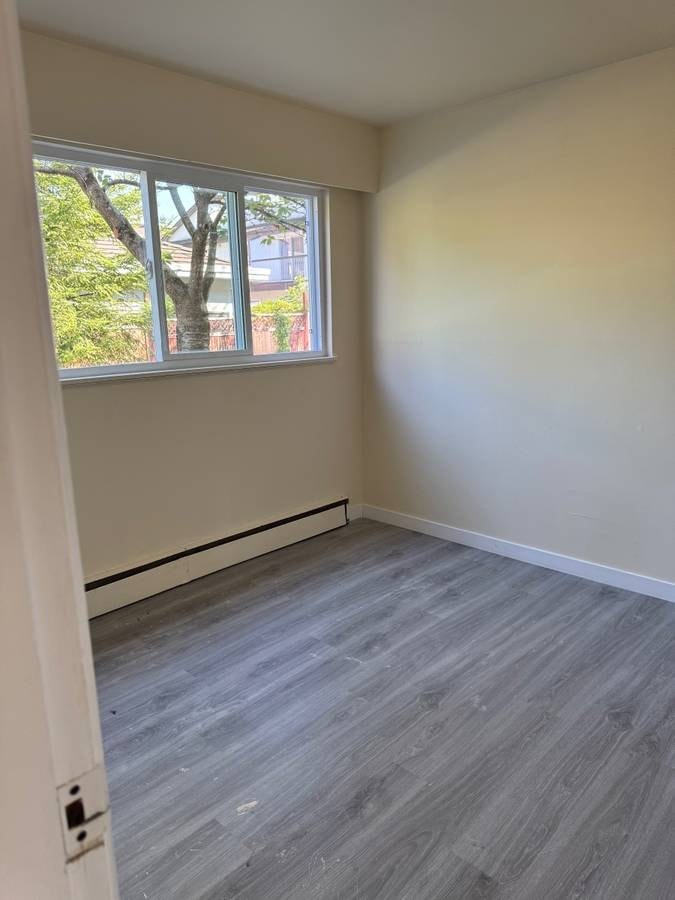 A room with a window and a grey floor.